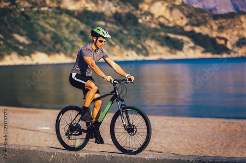 Man ride mountain bike on the beach. Sport and active life concept.