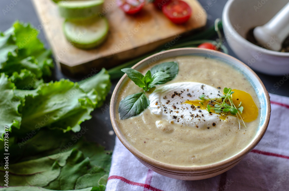 Healthy zucchini cream soup served with poached egg and greens. Proper nutrition food Healthy zucchini cream soup served with poached egg and greens. Proper nutrition food