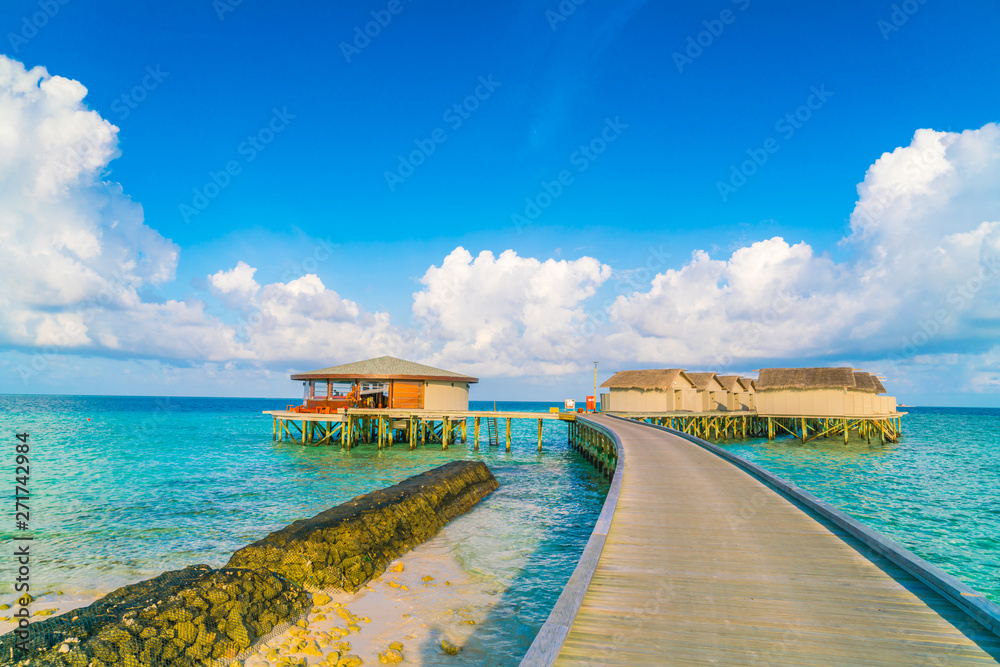 Beautiful water villas in tropical Maldives island at the sunrise time .