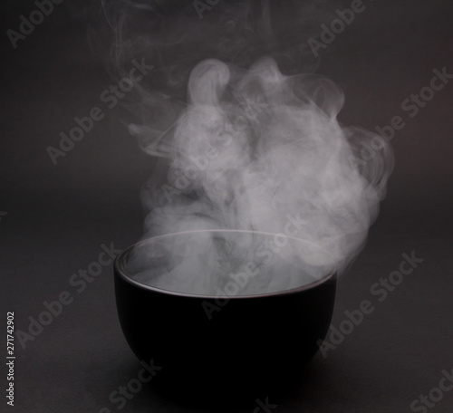 Bowl of hot soup on black background 