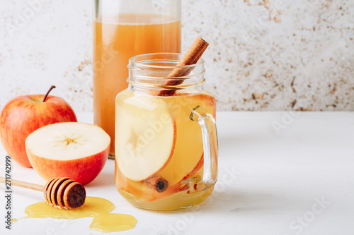 Cool, healthy drink with apple cider vinegar, honey, apples and cinnamon photo