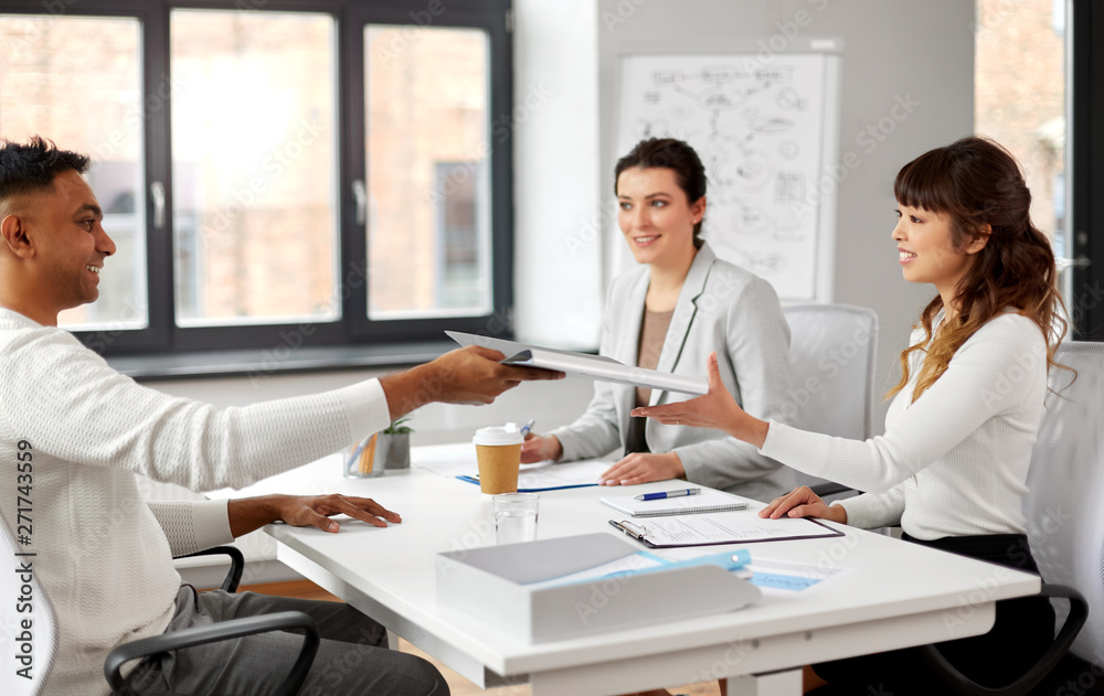 Fototapeta premium new job, hiring and employment concept - international team of recruiters having interview with indian male employee at office