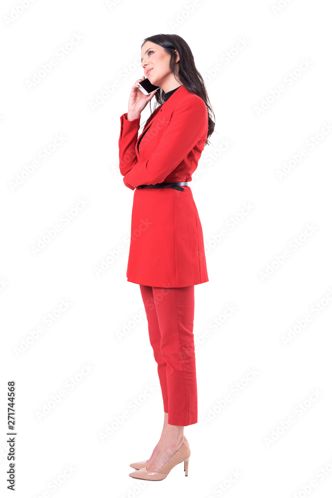 Side view of relaxed smiling corporate woman talking on the phone and looking up thoughtfully. Full body isolated on white background. Side view of relaxed smiling corporate woman talking on the phone and looking up thoughtfully. Full body isolated on white background.