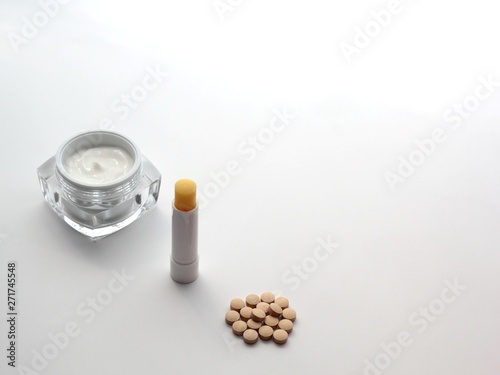 Set of items relieving side effects of isetretinoin treatment: moistuiser, lip balm and milk thistle. 