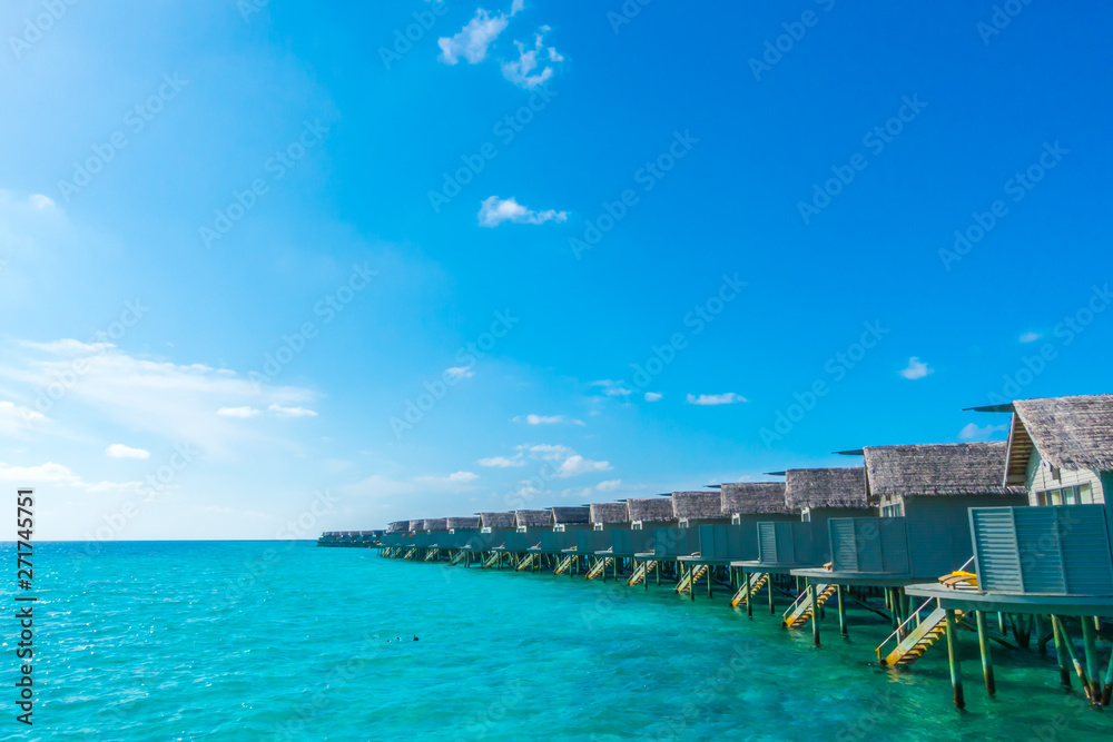 Water villas over calm sea  in tropical Maldives island .
