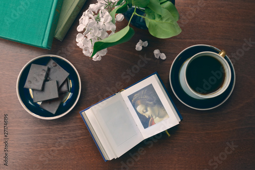 Coffee table from above. Reproduction fragment of Madonna Litta by Leonardo da Vinci is on the notebook page. photo