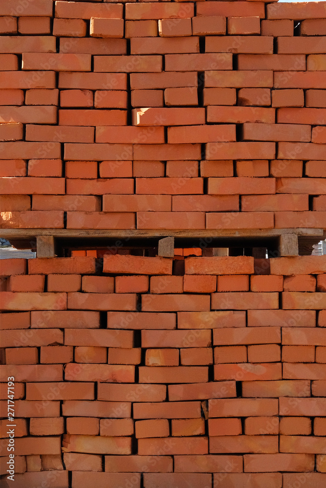 Obraz premium Construction Materials. Pile of red bricks at construction site. Building materials for construction of buildings and structures. Close up.