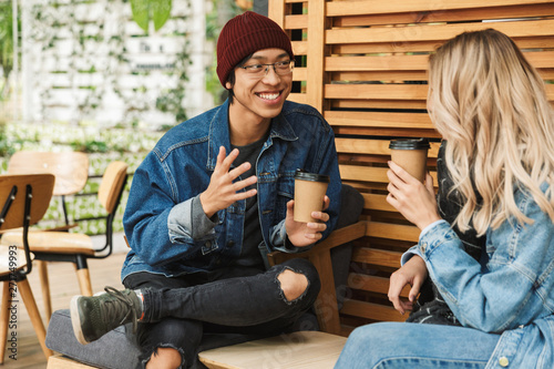 Smiling multhiethnic couple sititng at the cafe outdoors photo