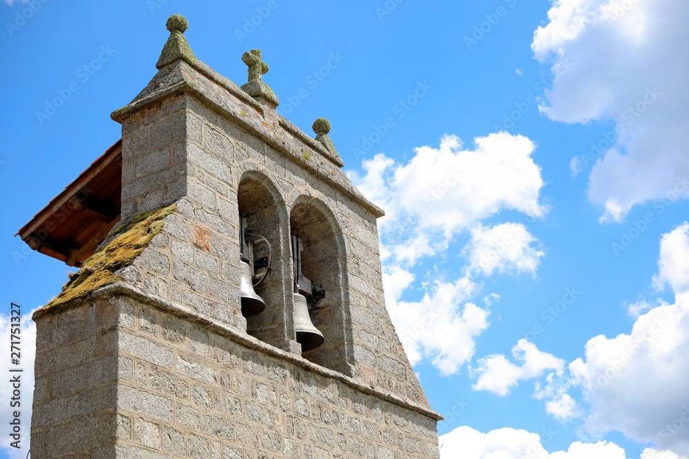 Clocher d'une église catholique en pierre avec ces deux cloches. Église et croix en Haute Loire, Auvergne France. Paysage et village de campagne française.