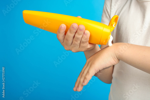 Boy smears his hands with children's sunscreen