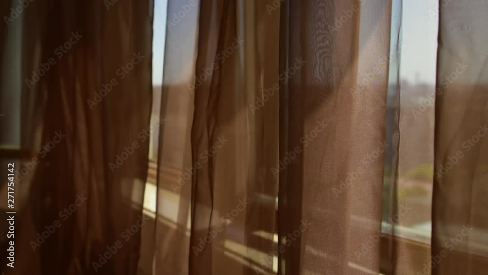 Moving brown transparent voile at wide open window Moving brown transparent voile at wide open window