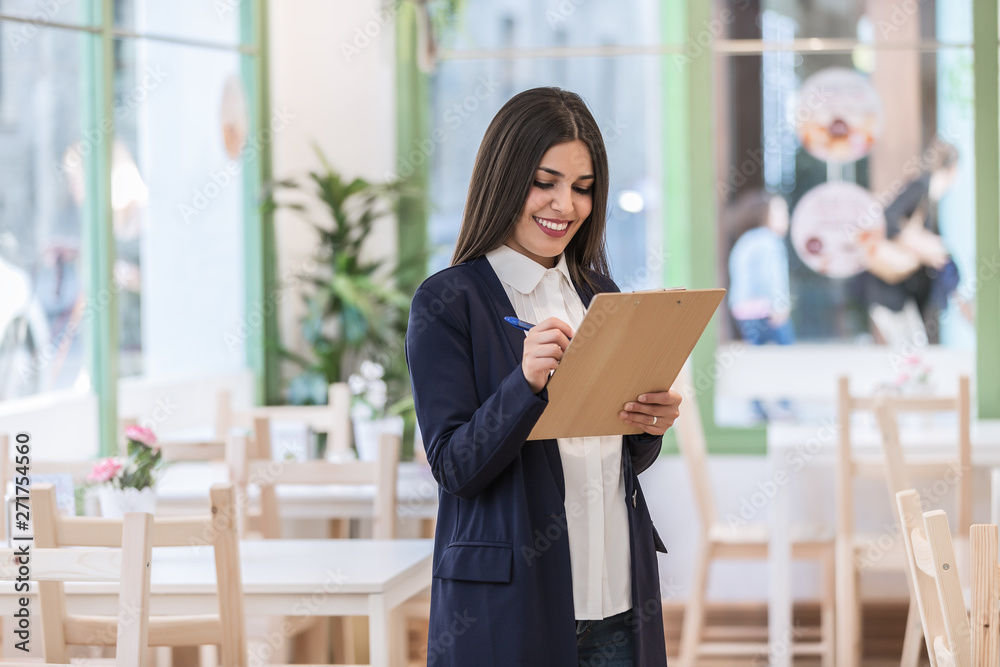 Fototapeta premium Woman writing notes on clipboard