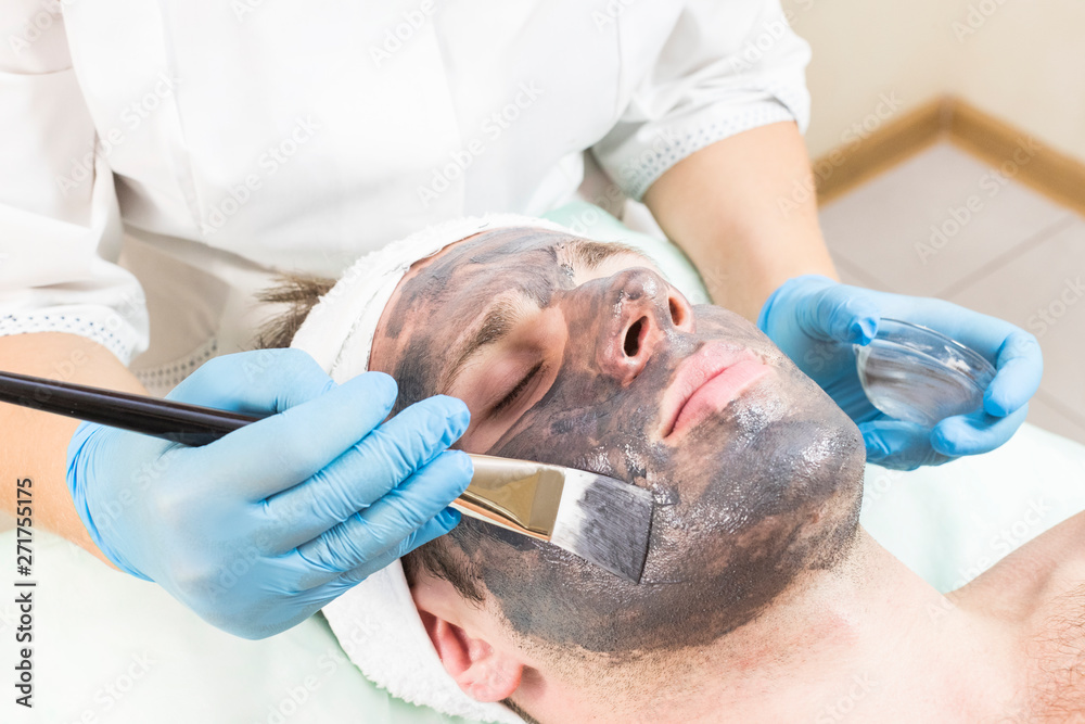 A young man is undergoing a mask treatment in a beauty salon spa. A young man is undergoing a mask treatment in a beauty salon spa.