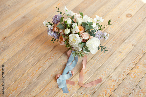 Close-up bouquet of roses peonies freesia dianthus flowers on the round white floore indoors photo