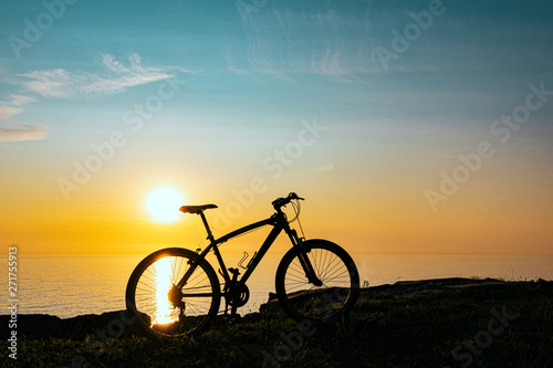 Fototapeta Naklejka Na Ścianę i Meble -  beautiful sunset on the sea and the silhouette of a bicycle