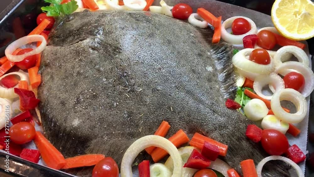 Mediterranean diet. Halibut fish cooking with vegetables in the oven