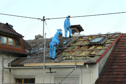 Dachdecker decken Dach mit Asbestfaserzementplatten ab
