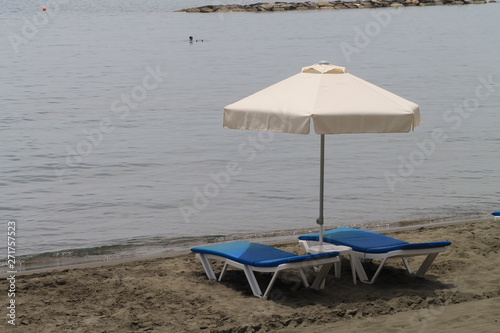 Umbrella and two sun beds on a beach