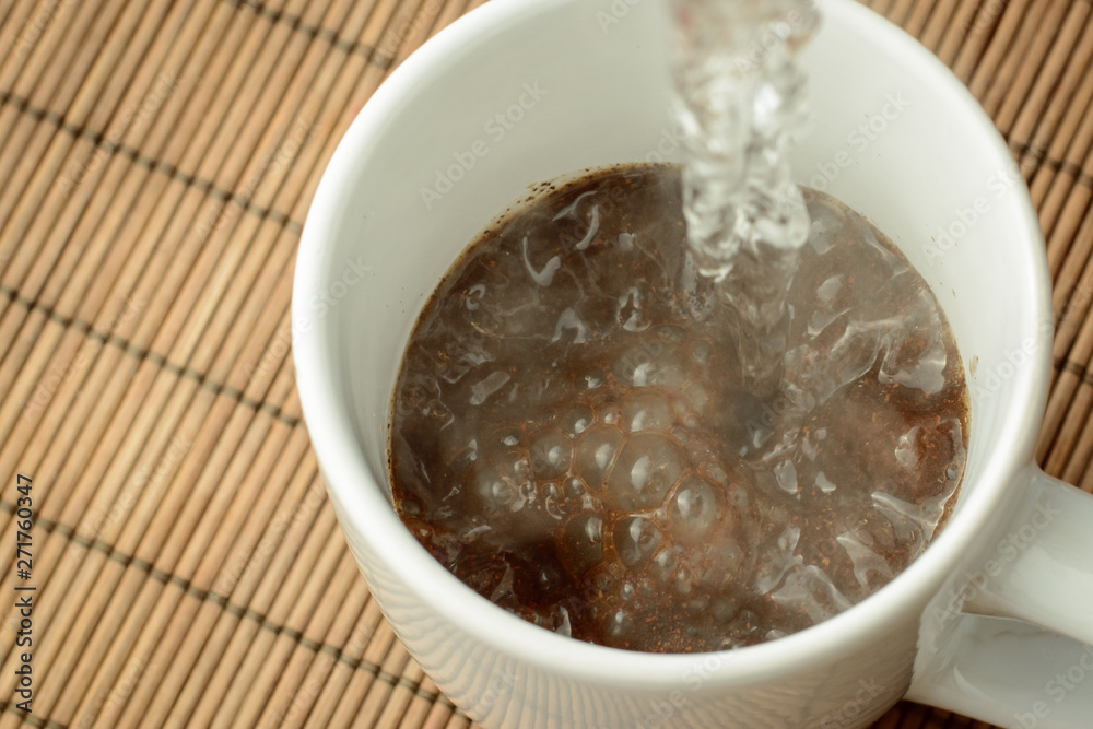 Pouring boiling water to the cap with ground coffee and sugar. Making coffee in the morning. Refreshing in the morning. Pouring boiling water to the cap with ground coffee and sugar. Making coffee in the morning. Refreshing in the morning.
