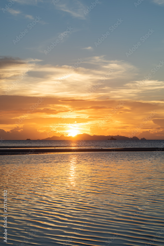 Beautiful beach sunset with blue sea and golden light sky  cloud background