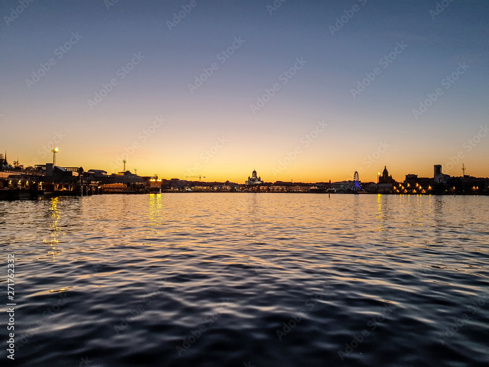 Fototapeta premium The Helsinki city skyline by night from the sea, shot during the beautiful and almost nightless Finnish summer
