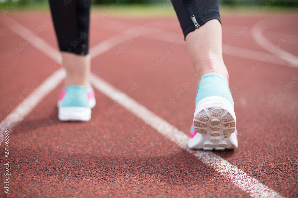 Young fitness woman legs running at morning on treadmill.Athletic woman feet on running track, close up on shoe.Woman wear sport shoe on to run in running court background. Health exercise life style 