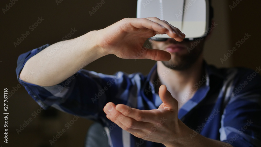 Portrait of an young man is using  futuristic vr  glasses with latest innovation technology with augmented reality hologram. 