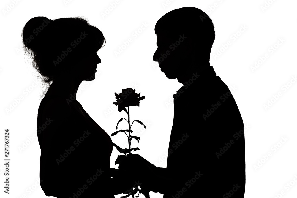 silhouette of a young couple in love on white isolated background, man gives a woman a rose flower, concept love