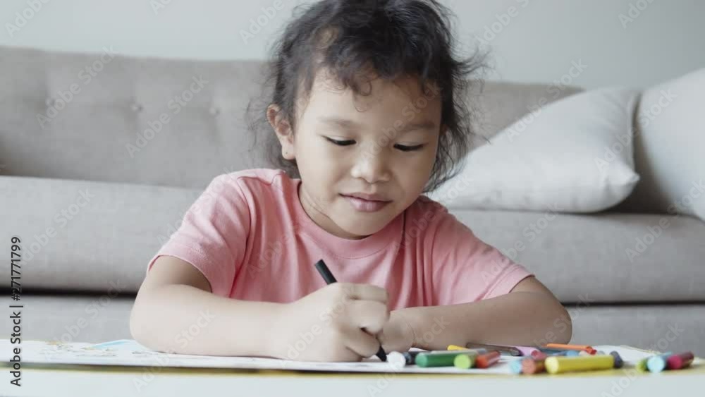 Asian girl wearing casual dresses are drawing and smiling happily at home. Asian girl wearing casual dresses are drawing and smiling happily at home.