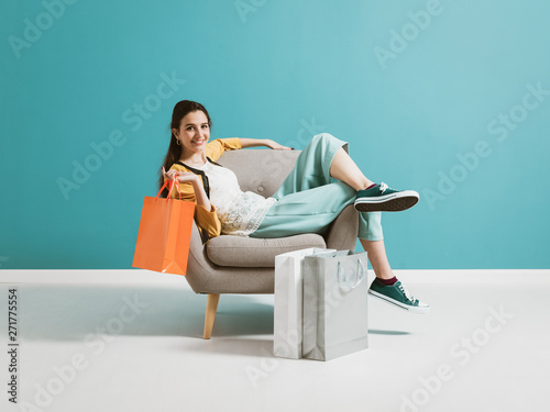 Cheerful shopaholic woman with shopping bags