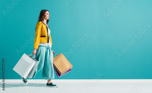 Smiling woman walking and holding shopping bags