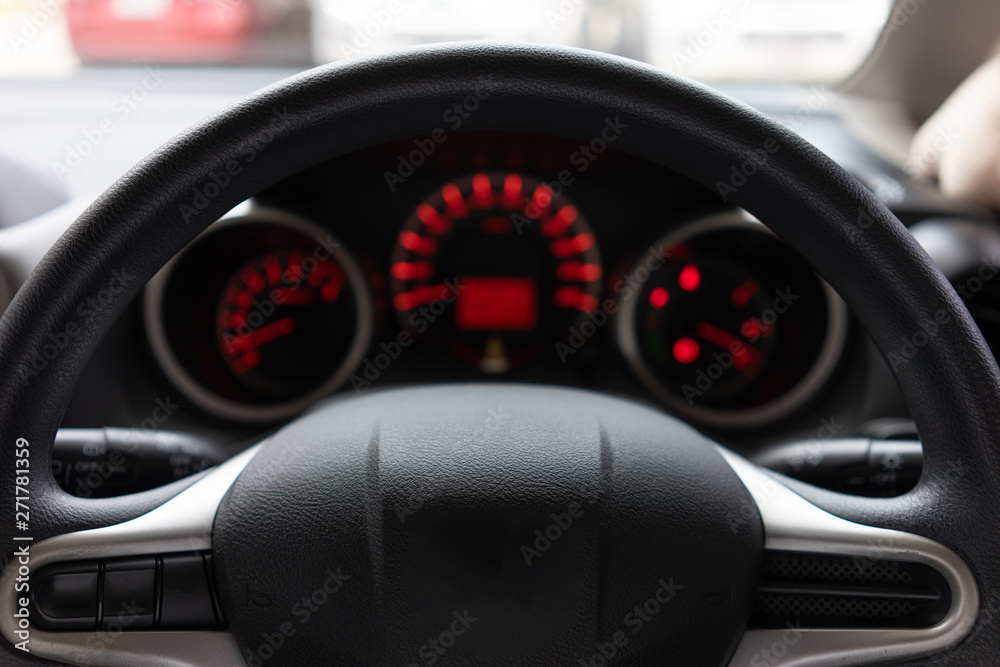Blurred background with Modern Car dashboard modern automobile control illuminated panel.Car Driving. Vehicle Steering Wheel.