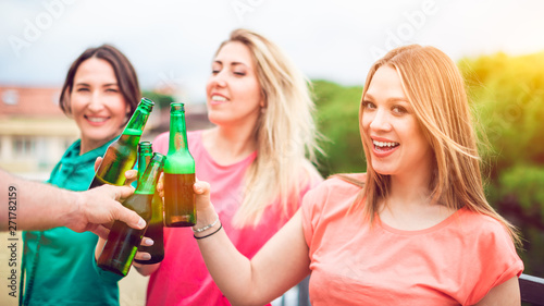 Young women clinking with beer bottles - party and friendship concept - POV image