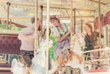 Gruppe von Freunden fährt mit dem Karussell auf dem Jahrmarkt Vergnügungspark