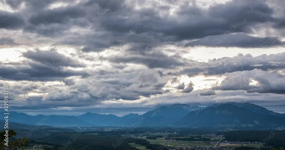 Timelapse of fast moving dark grey clouds moving above a farming village during sunset. Timelapse of fast moving dark grey clouds moving above a farming village during sunset.