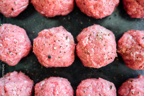 Raw uncooked meatballs on tray
