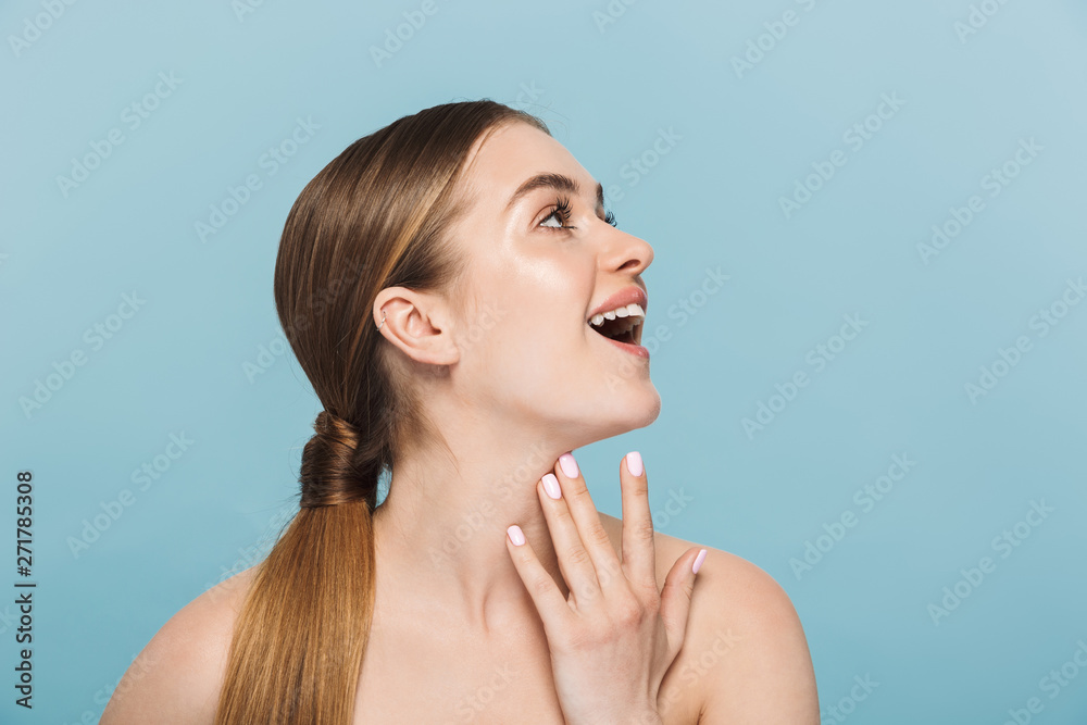 Pretty happy excited young woman posing isolated over blue wall background. Pretty happy excited young woman posing isolated over blue wall background.