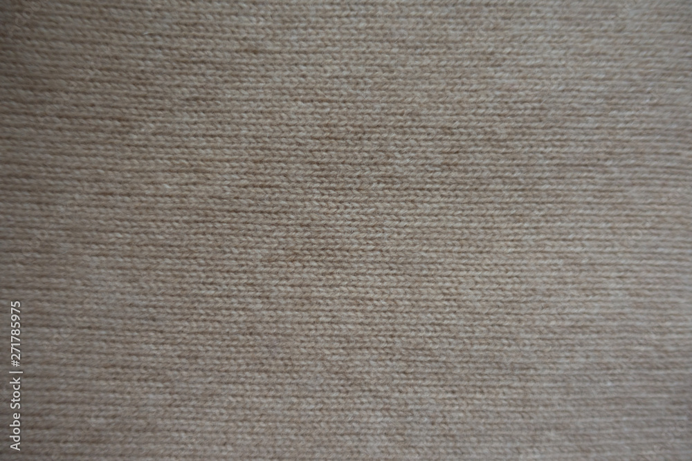 View of simple beige knitted fabric from above View of simple beige knitted fabric from above
