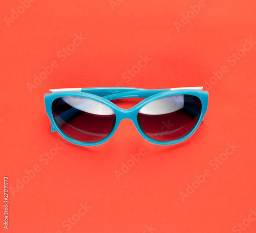 Stylish blue sunglasses on orange background. Summer is coming concept.