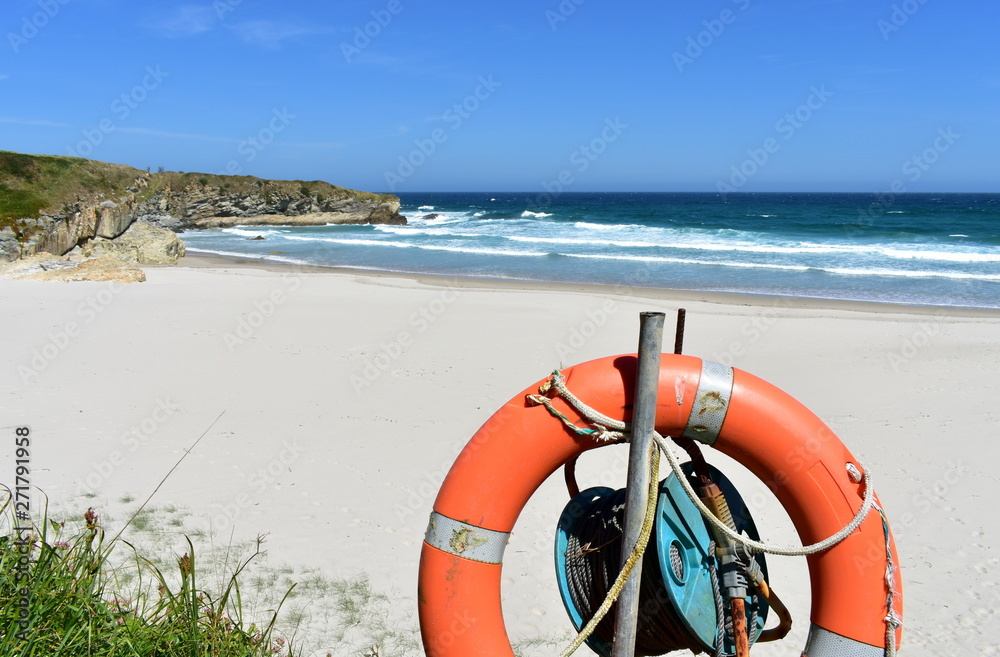 Beach with white sand, waves and life preserver. Lugo, Spain.