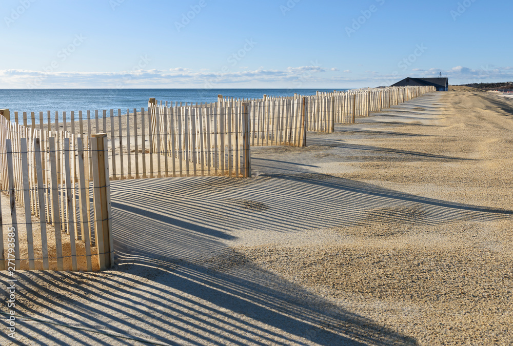 Row of Beach Fences with Shadows in Sand