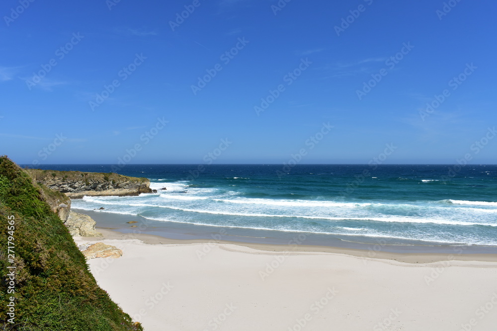 Beach with white sand, rocks and waves. View from a cliff, Lugo, Spain.