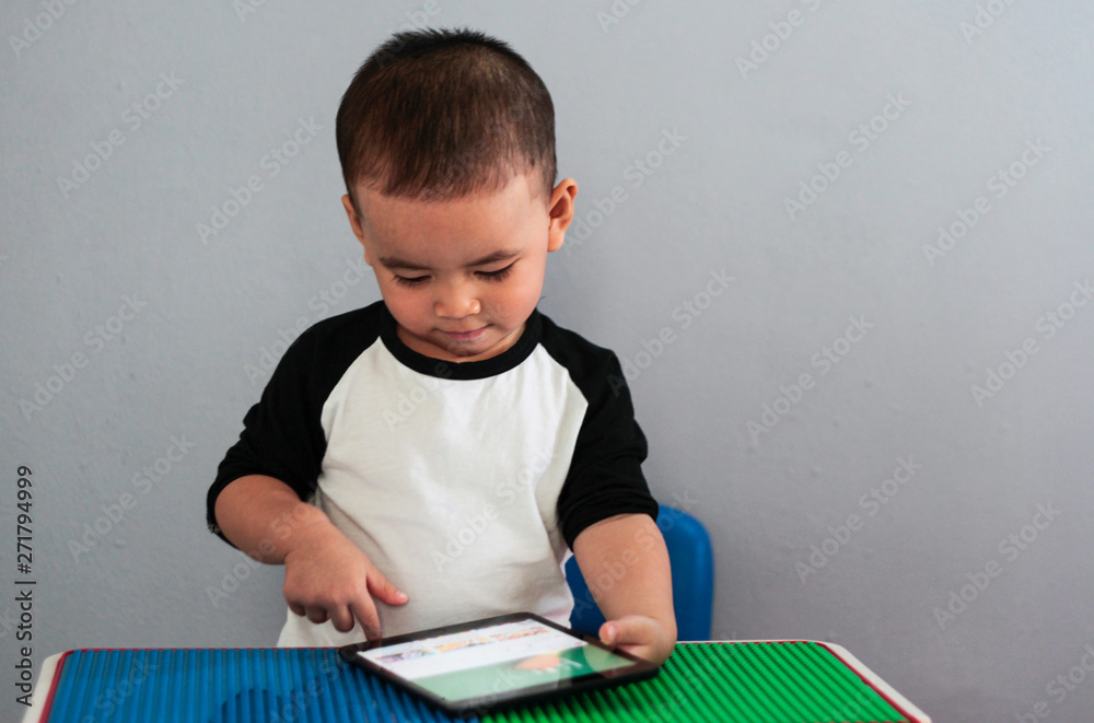 asian children watching tablet. playing phone and looking at cartoon. boy playing with digital tablet