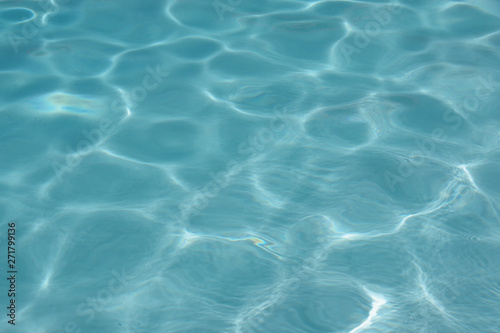 Close up full frame view of the reflecting water surface of a sunlit swimming pool