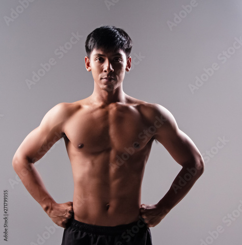 The handsome man show body muscle,from exercise,looking straight,good health,blurry light around