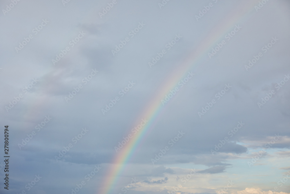 rainbow on blue sky background with clouds and sunlight rainbow on blue sky background with clouds and sunlight