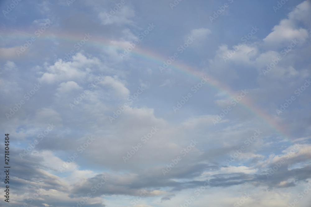 rainbow on blue sky background and white clouds