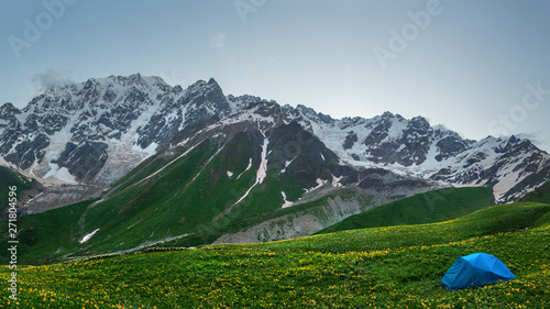 Hiking in mountains. Tent in mountain. Tourist camp in highlands. Trekking in wild mountains