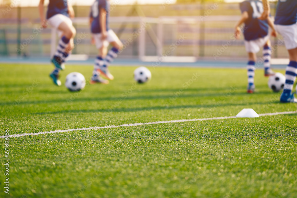 Fototapeta premium Blurred Soccer Field at School. Young Soccer Players Training on Pitch. Soccer Stadium Grass Background