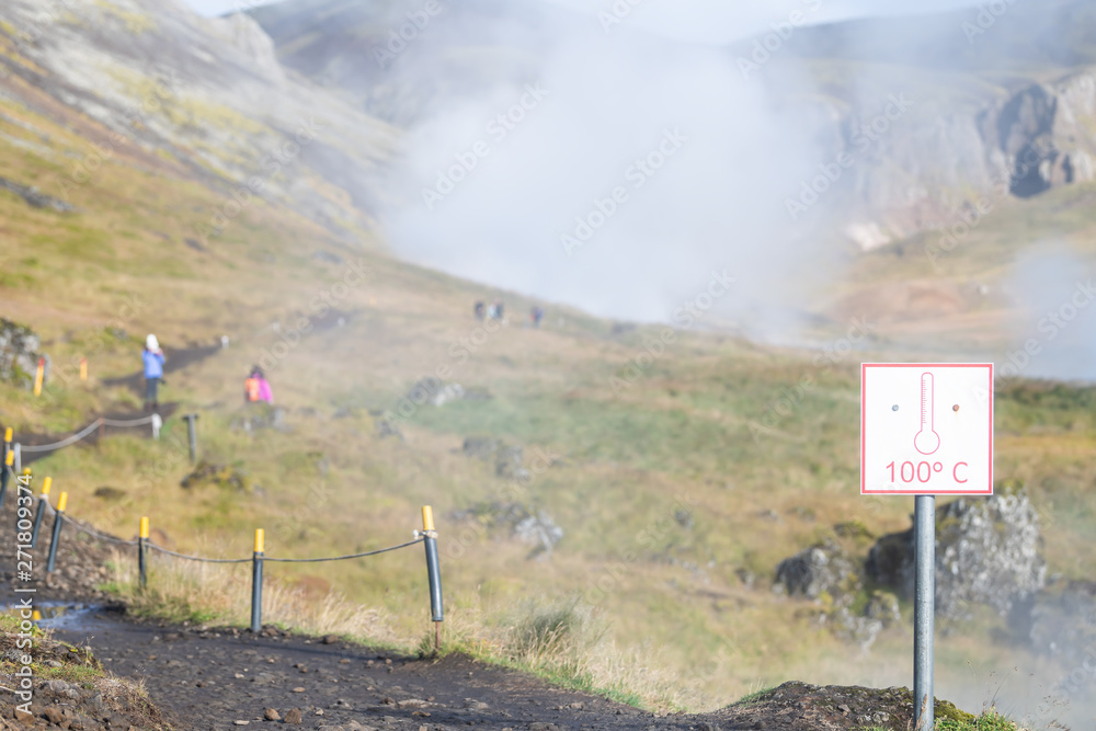 Naklejka premium Reykjadalur, Iceland Hveragerdi Hot Springs road footpath with steam during autumn landscape morning in golden circle with sign for celsius temperature red warning